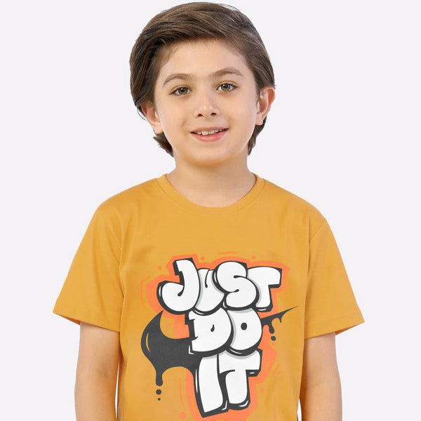 Child wearing a mustard yellow t-shirt with 'Just Do It' graphic on a white background